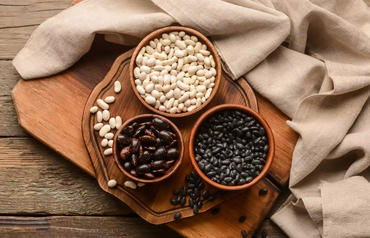 Wooden bowls with assorted beans on a wooden chopping board