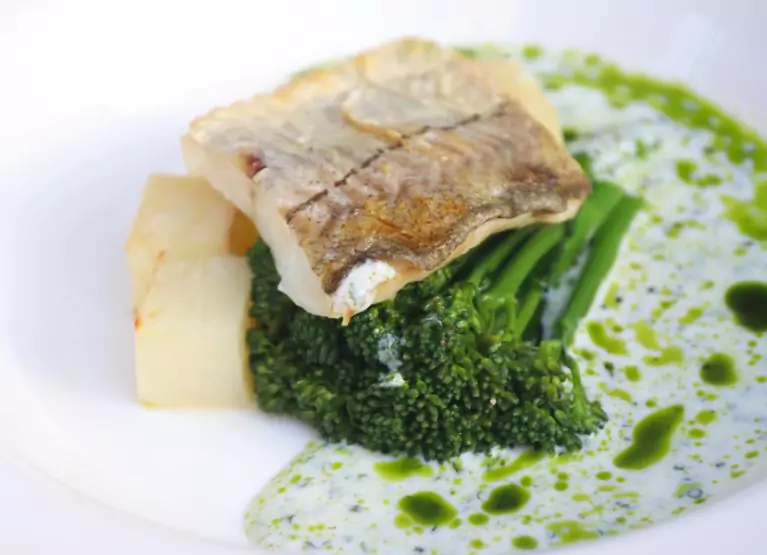 A plate of tilapia fillet with steamed broccoli