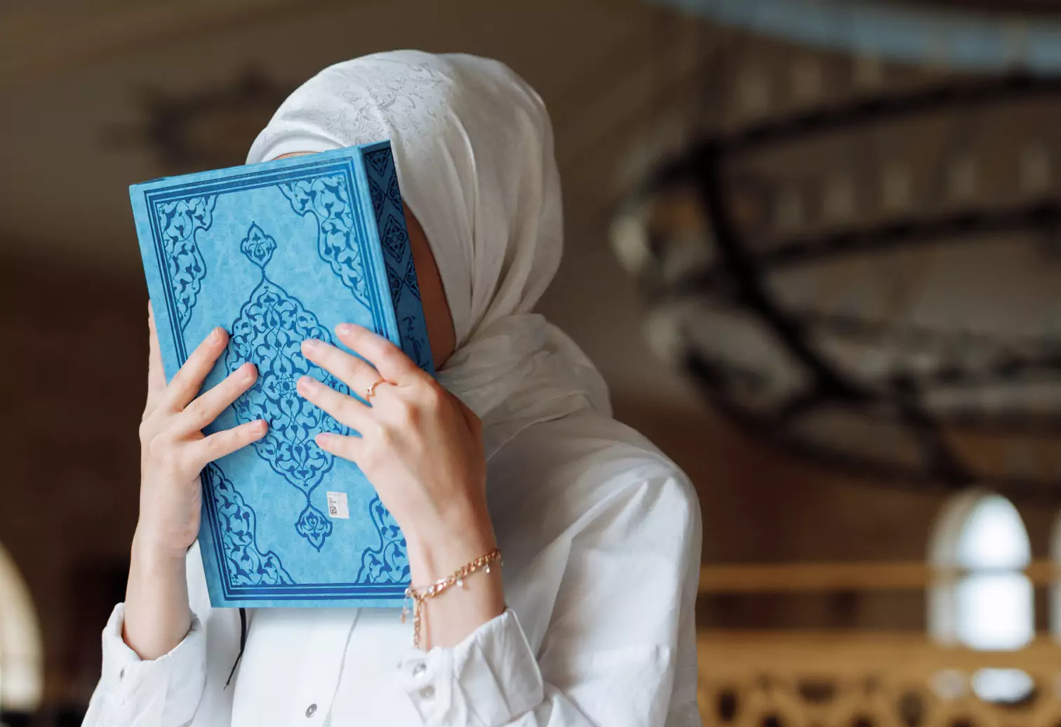 a person holding Quran near their face