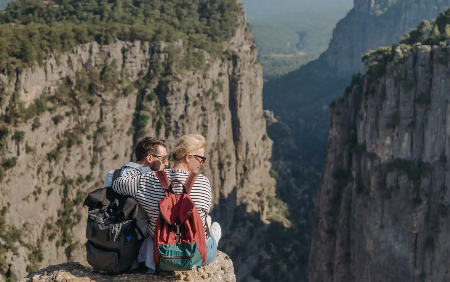 a couple of people sitting on the top of the mountain 