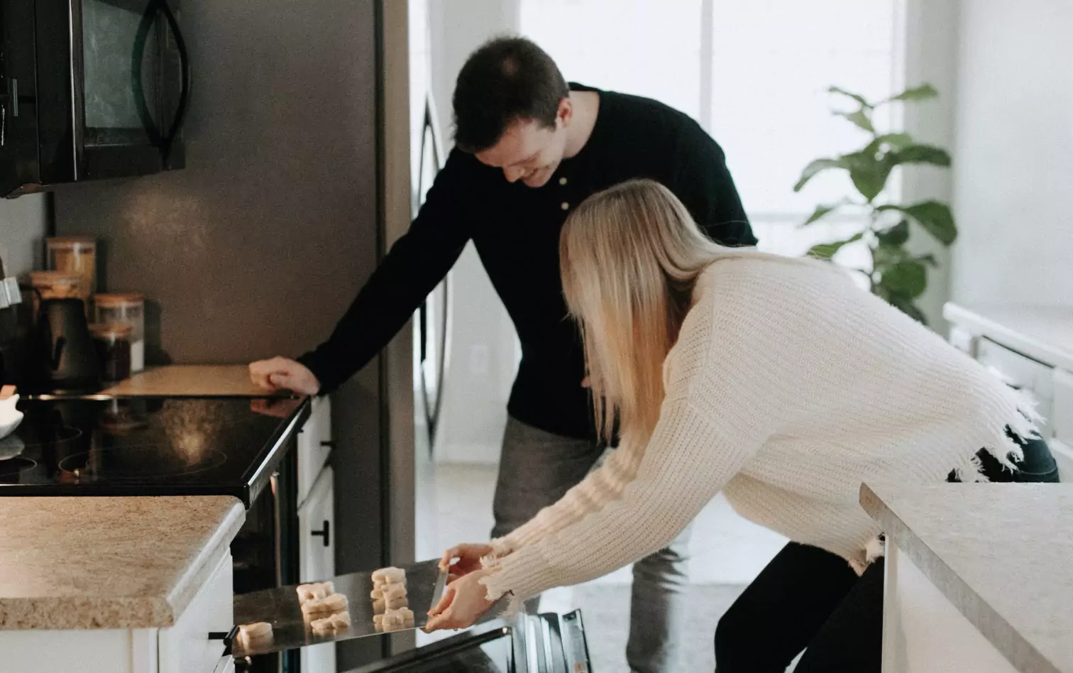 a couple of people baking cookies 