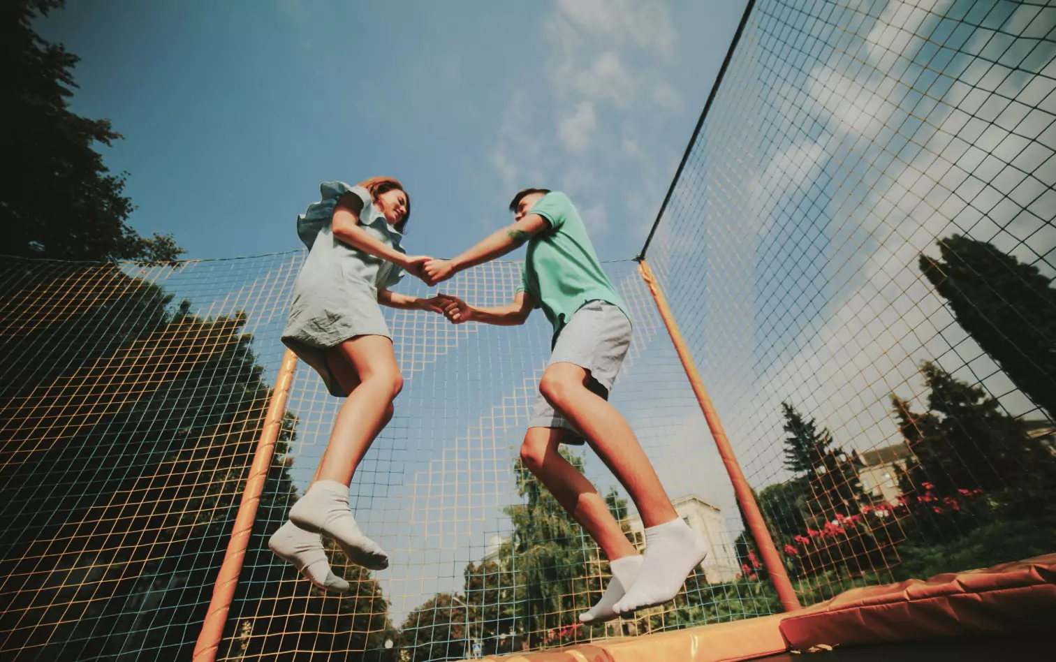 two people jumping on a trampoline 