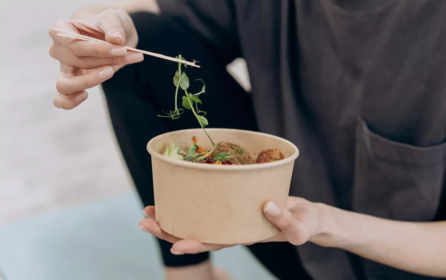 a person eating with chopsticks  