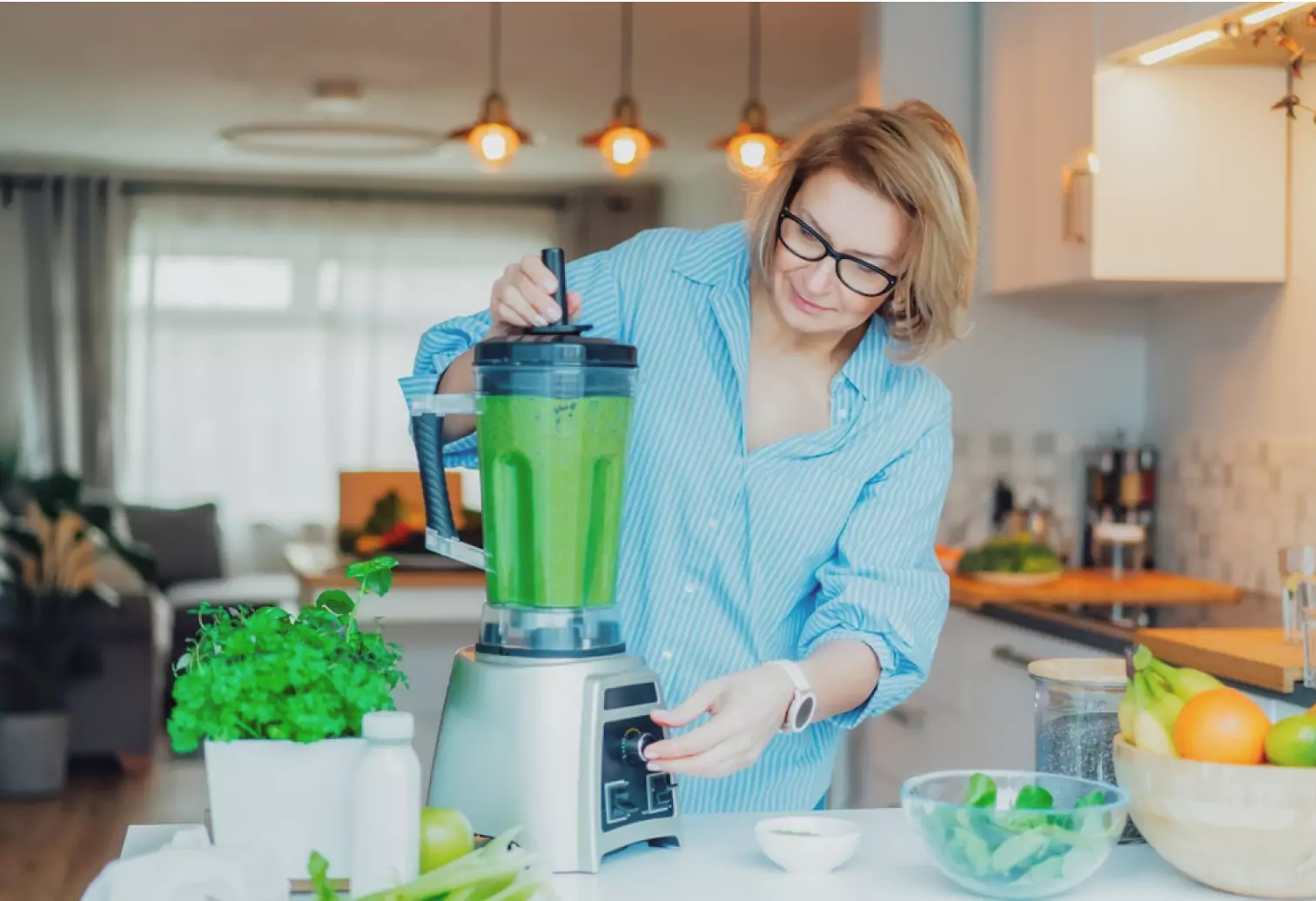 a person making a green smoothie 