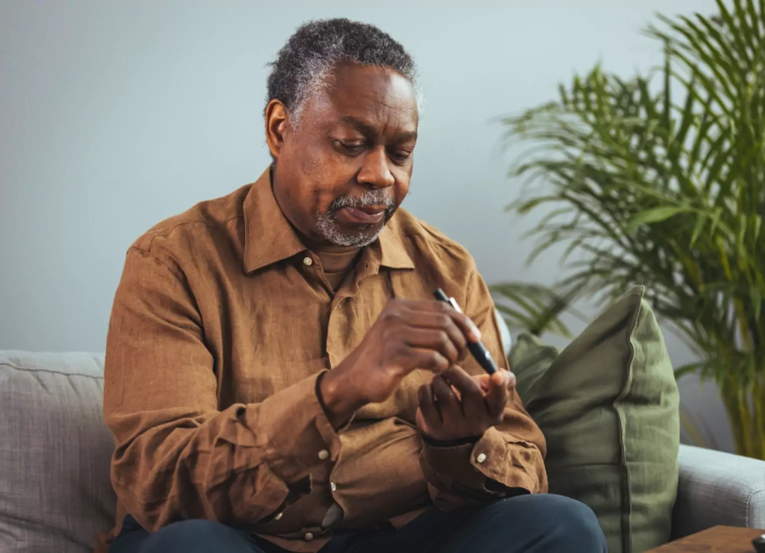 Man pricking his finger to check ketone levels