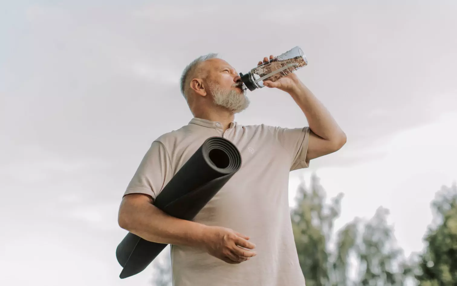 a person drinking water outdoors 