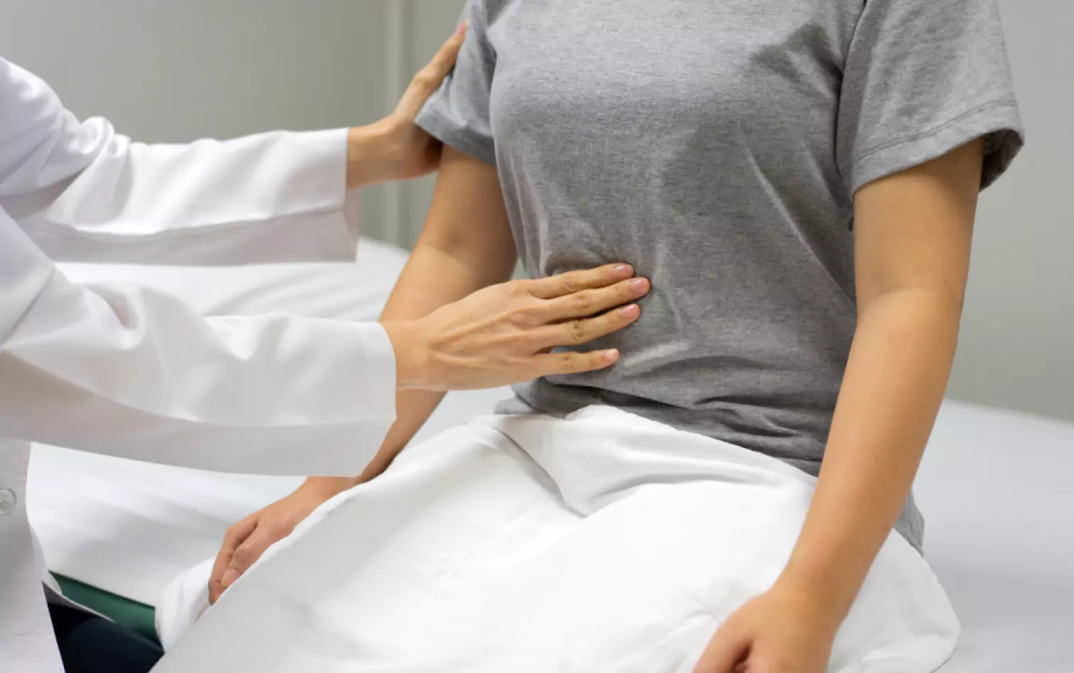 a doctor examining patient's stomach 