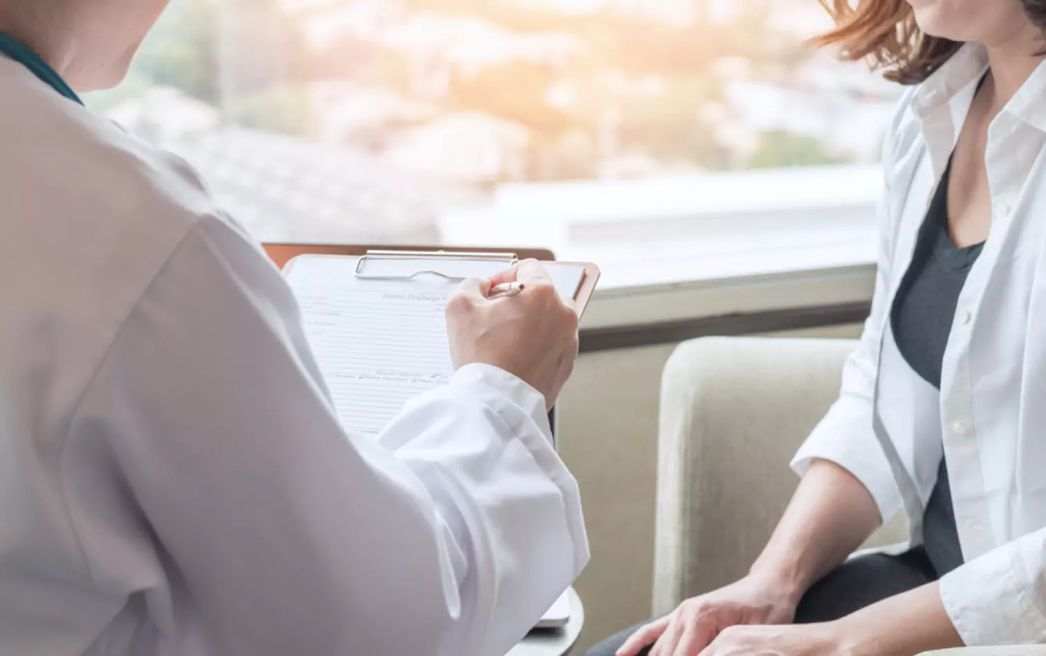 a doctor talking to a patient and making notes 