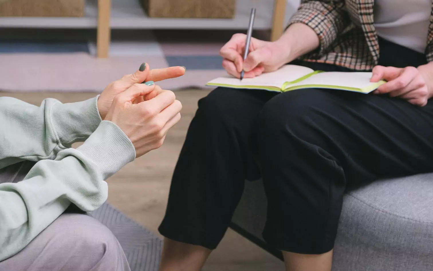 two people talking, one of them making notes 