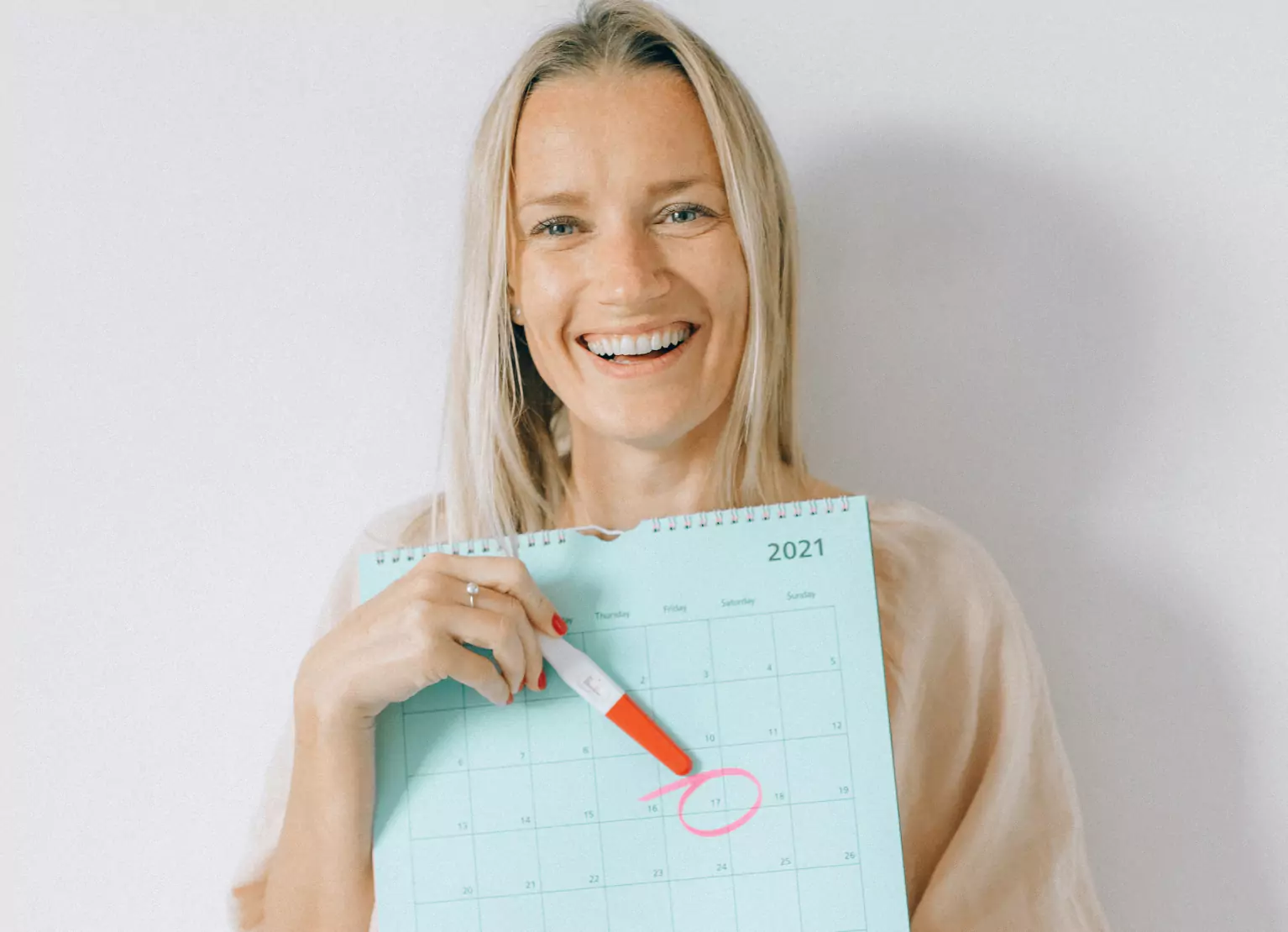 a woman showing a calendar with a cycled date 