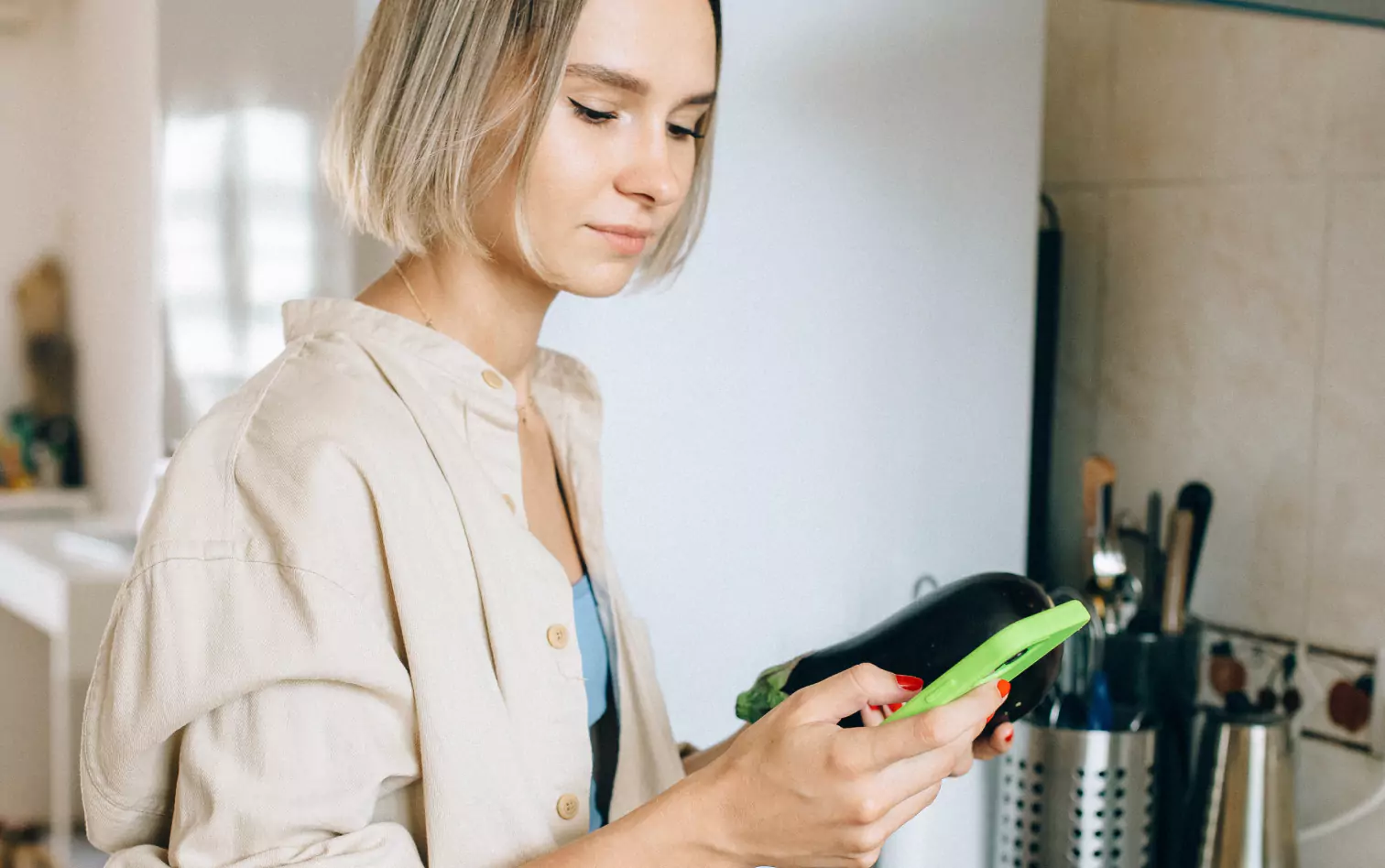 a person holding an eggplant and looking at their phone