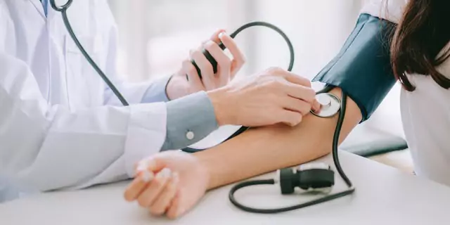 a doctor measuring patient's blood pressure 