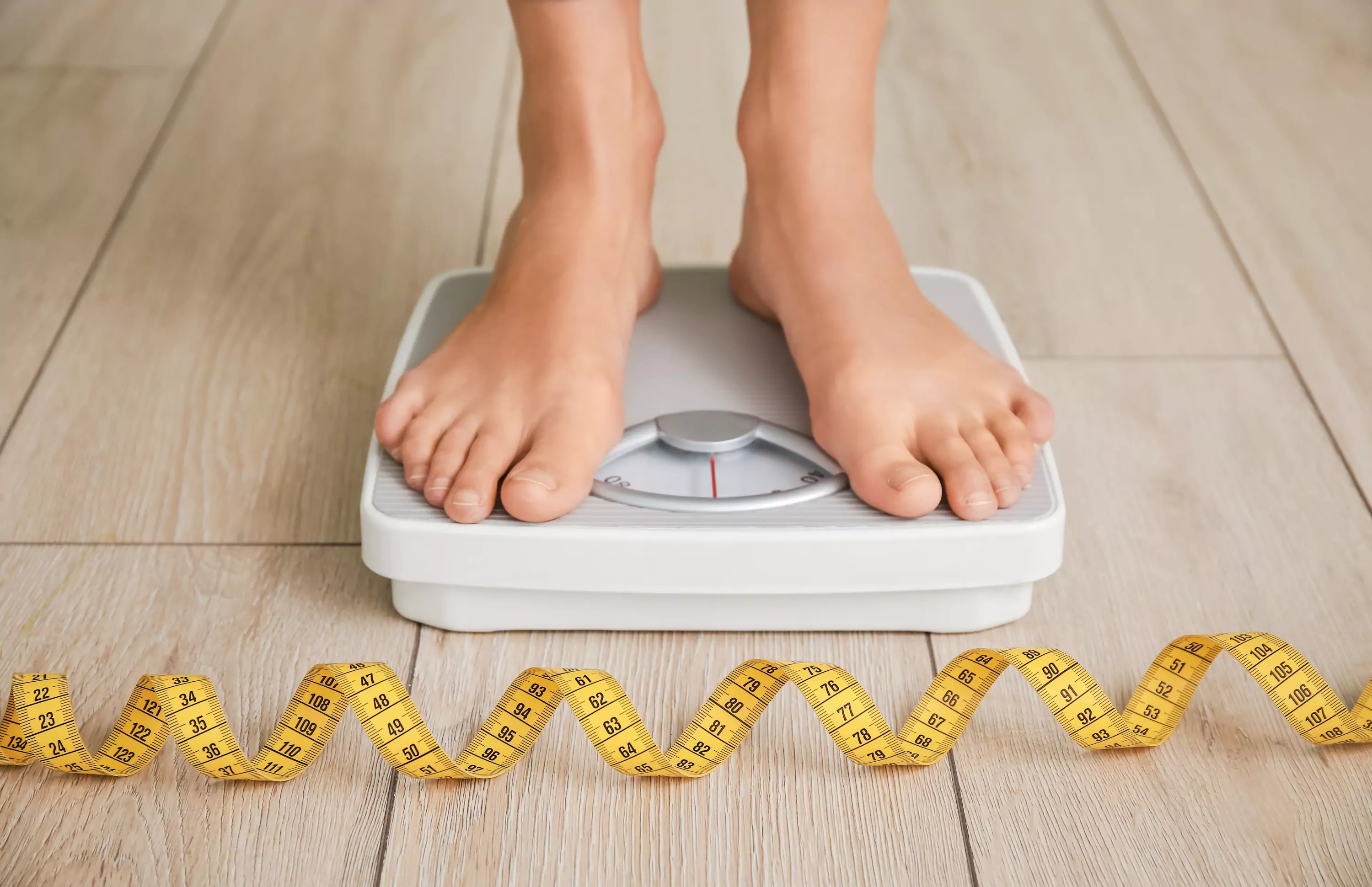 a person standing on the scale and tape measure