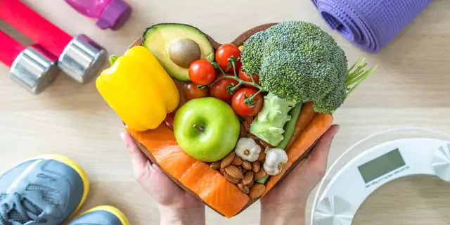 veggies fruits, nuts and fish on heart-shaped plate 