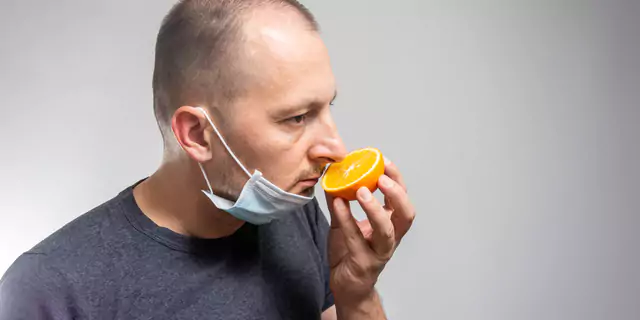 a person smelling an orange