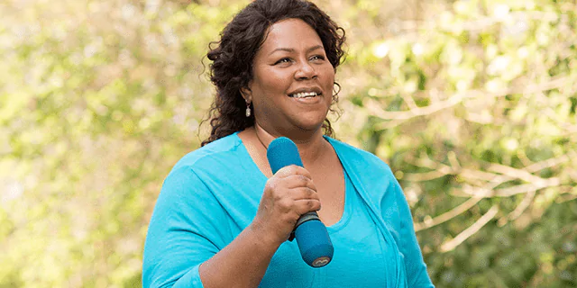 a person holding a dumbbell outdoors 