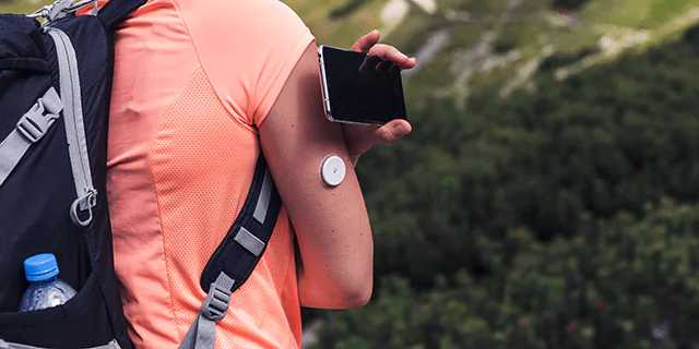 A person scanning a CGM sensor with a smartphone