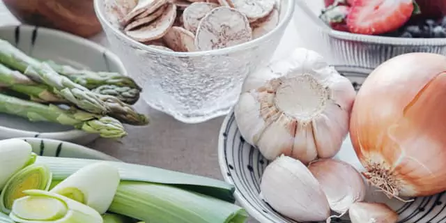 a head of garlic, onion, asparagus and leeks