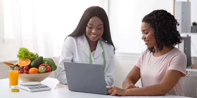 a person and a dietitian looking at a laptop 