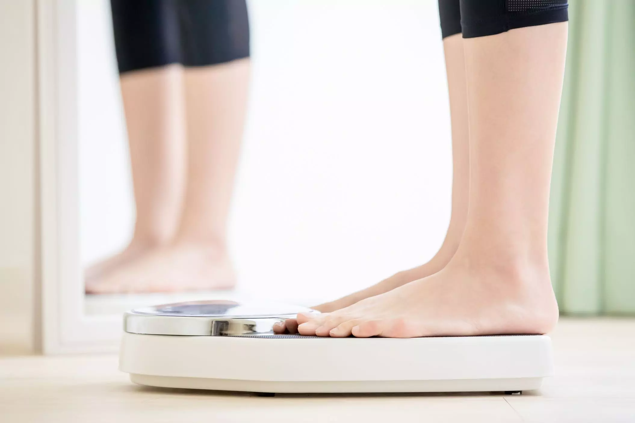 a person weighing themselves on a scale