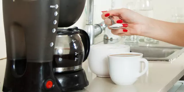 a person making a cup of coffee