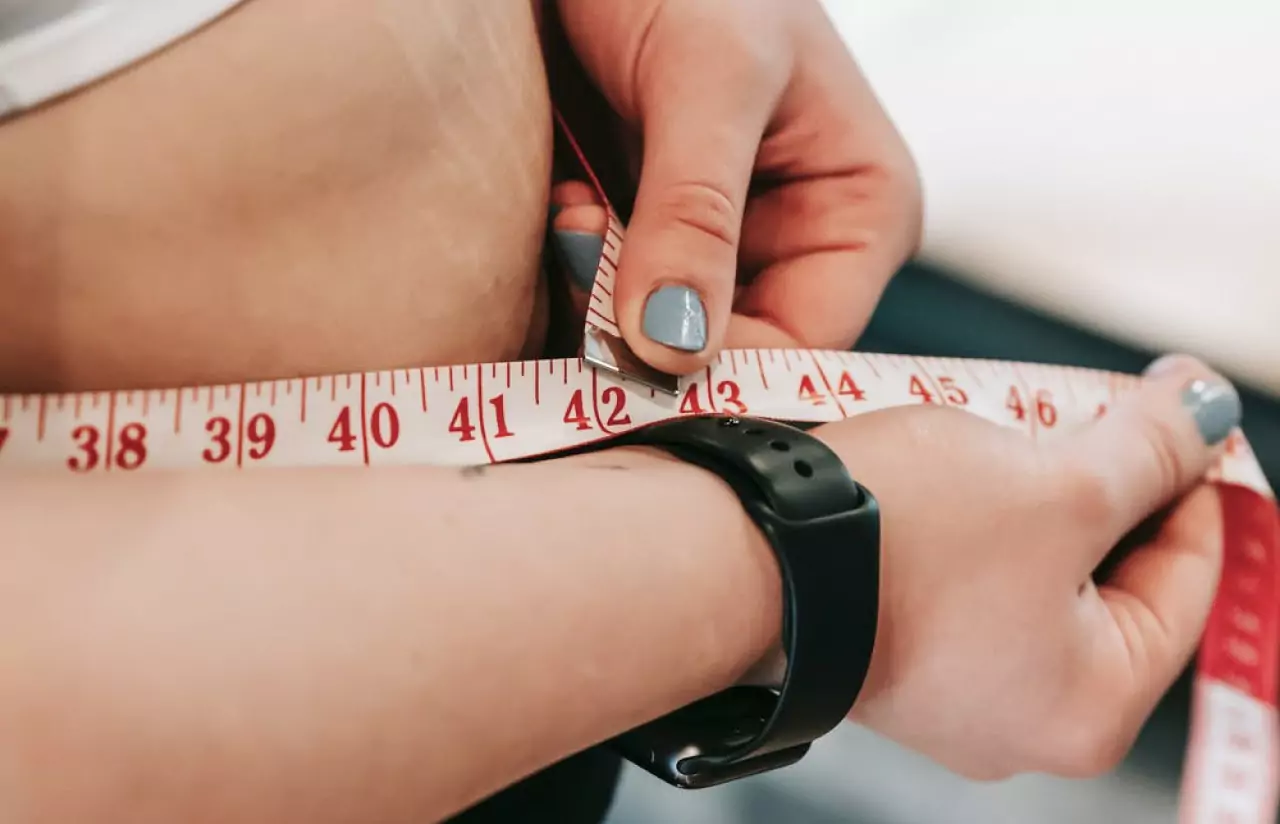 a person measuring their waist 