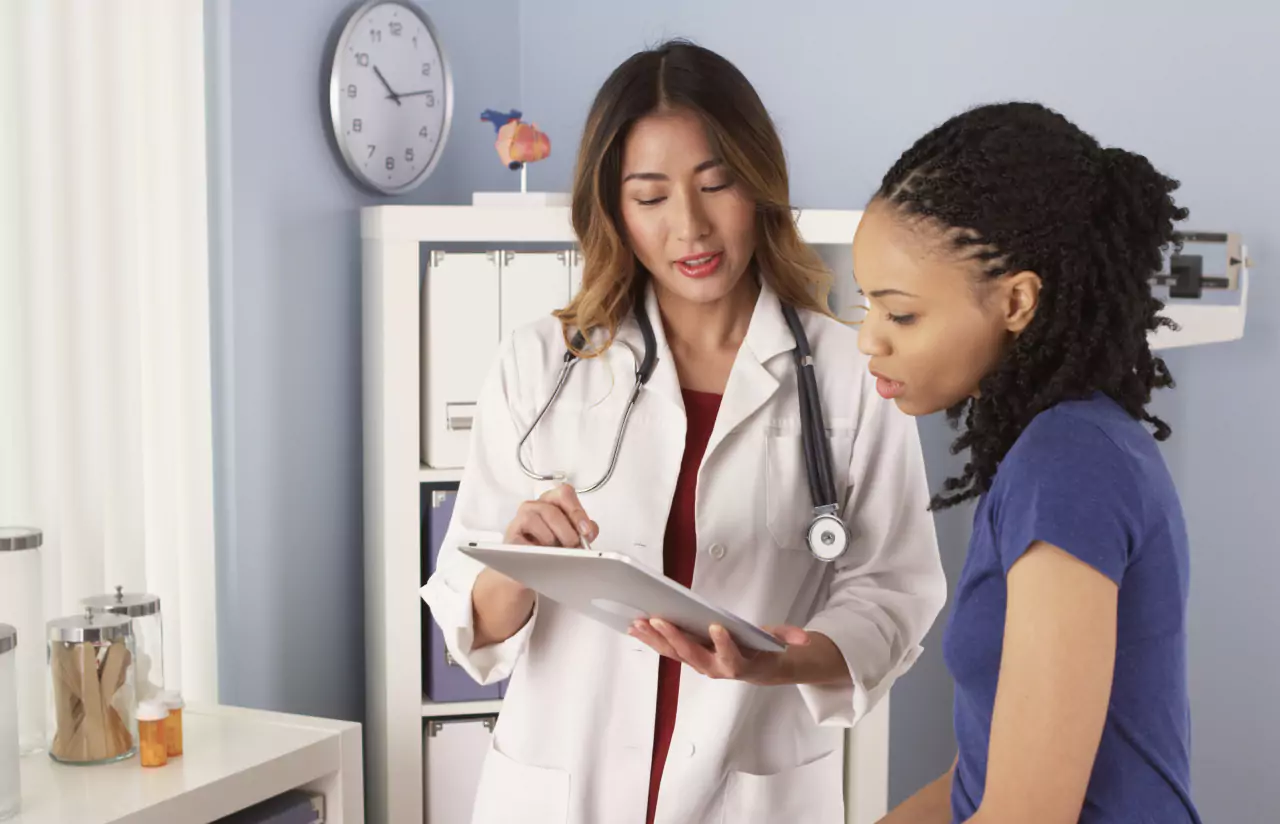 a person explaining something on a tablet to a patient 