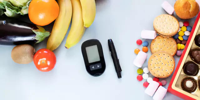 a glucose monitor in the middle of the picture, veggies an fruits on the left and cookies and candies n the right 