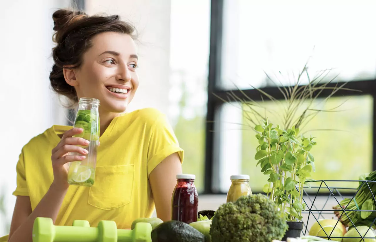 a person holding a bottle of water with lemons and smiling 