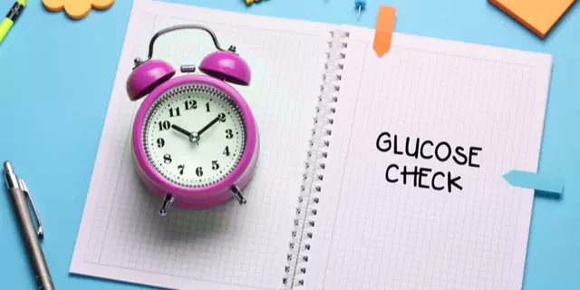 a clock and a notebook with glucose check written on it 