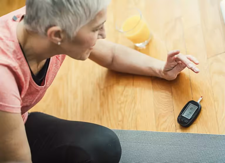Woman checking her blood glucose with finger prick method