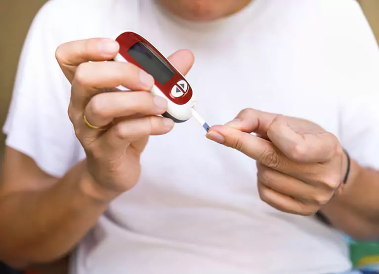 Person pricking their finger to check blood sugar levels