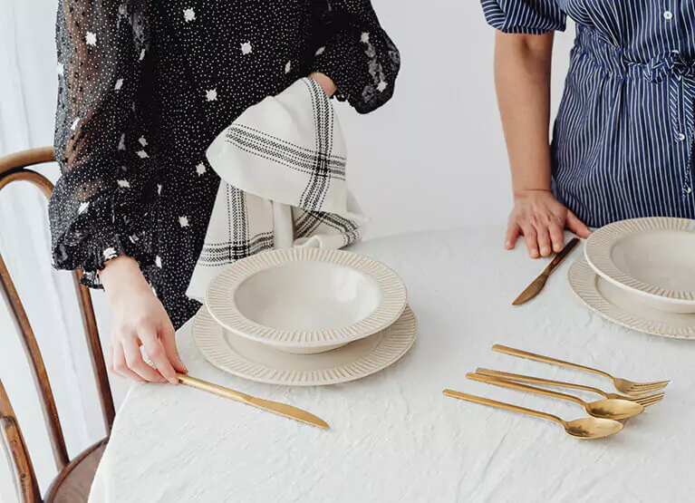 people standing at a table with plates set