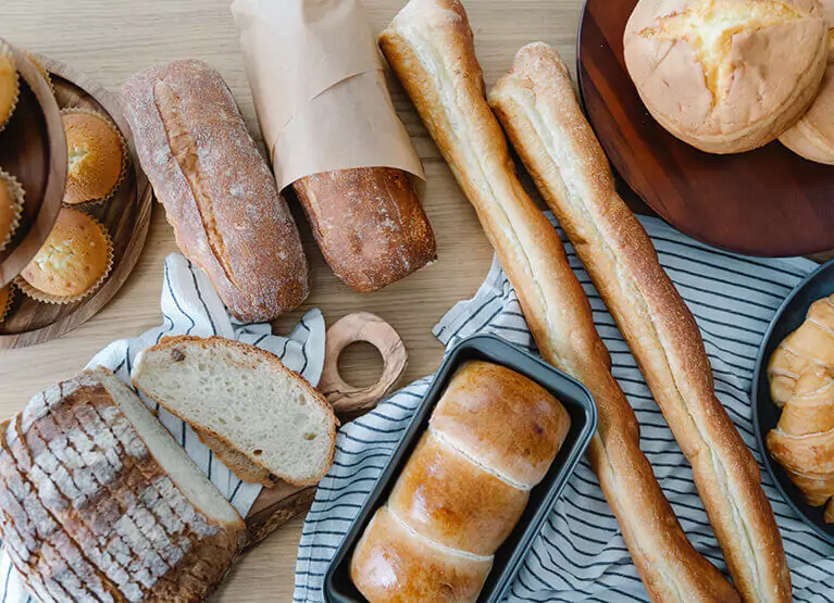 lots of baguettes and bread on a table