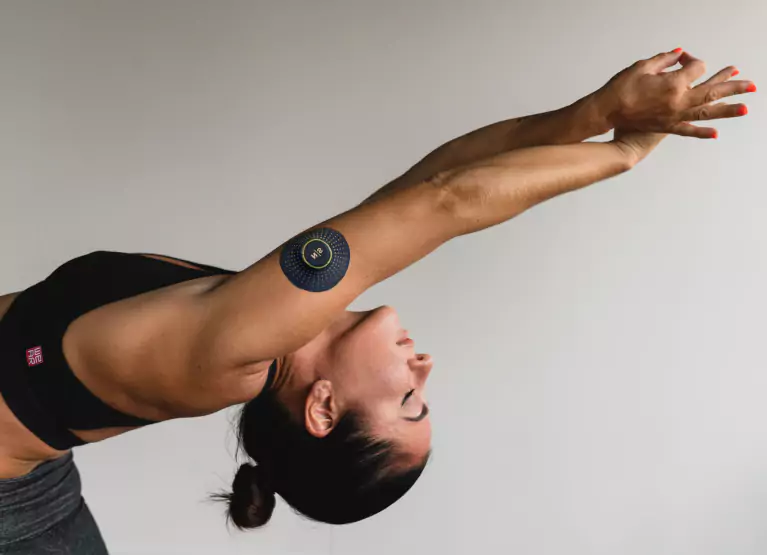 Woman with a Nutrisense CGM stretching arms