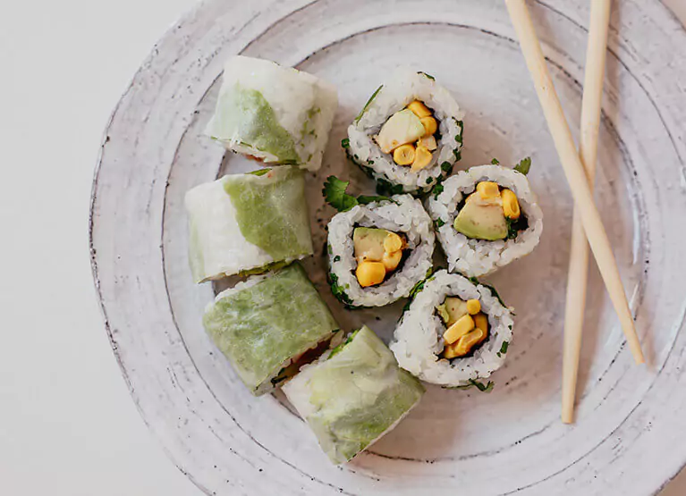 Plate with sushi rolls and chopsticks