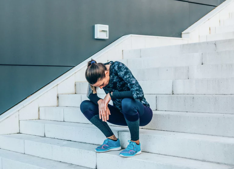 Woman in blue workout gear sitting on steps