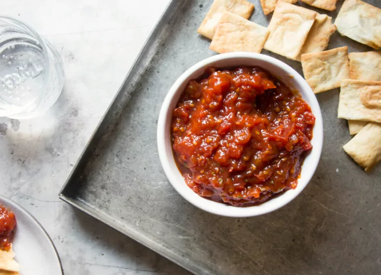 a bowl of hot sauce with dippers