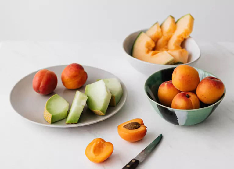 a few plates and bowls of chopped fruit