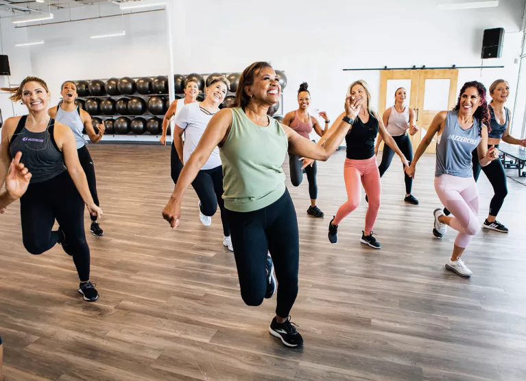 a group of women doing jazzercise at the gym