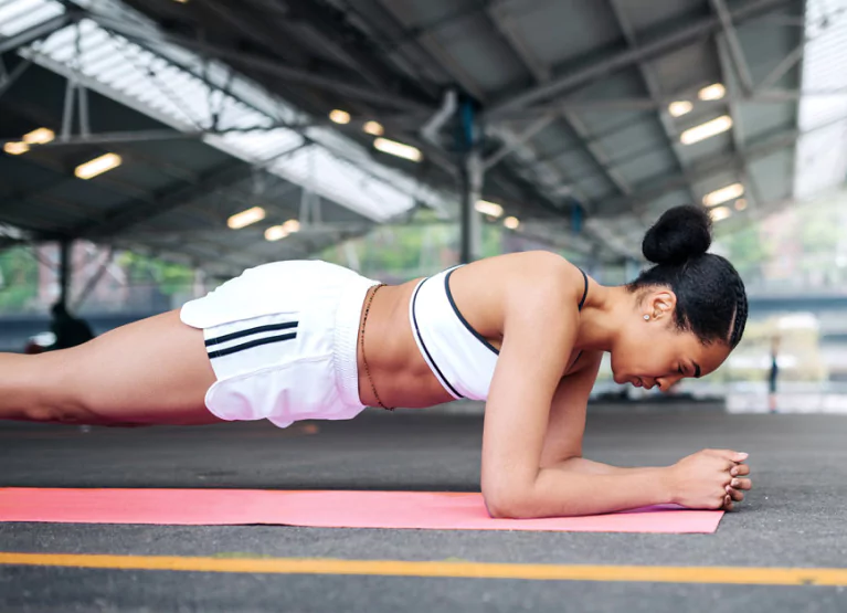 a girl doing a plank at the gym