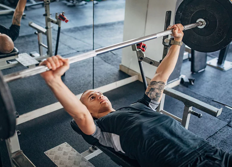 a man doing a barbell bench press