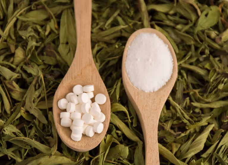 Two wooden spoons, one with splenda and the other with stevia