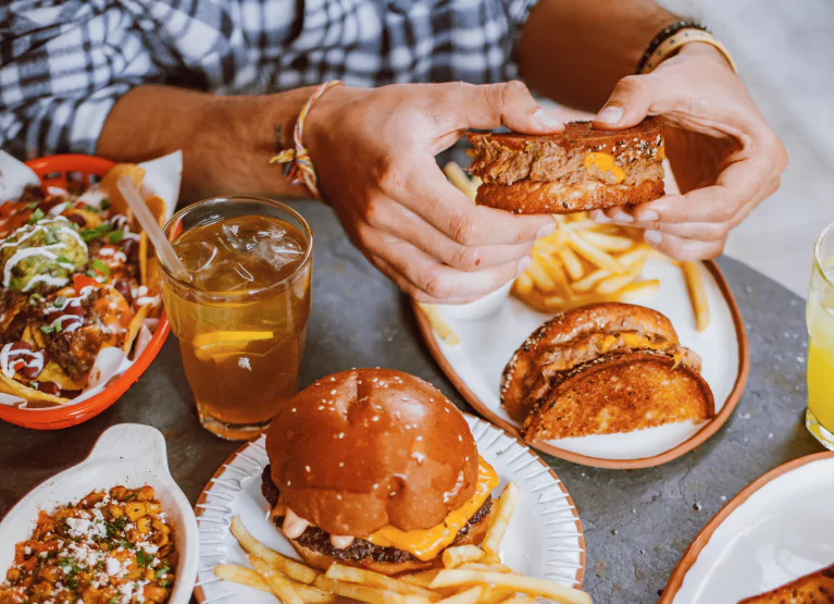 someone eating fries and a burger