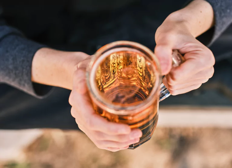 Person holding mug of beer