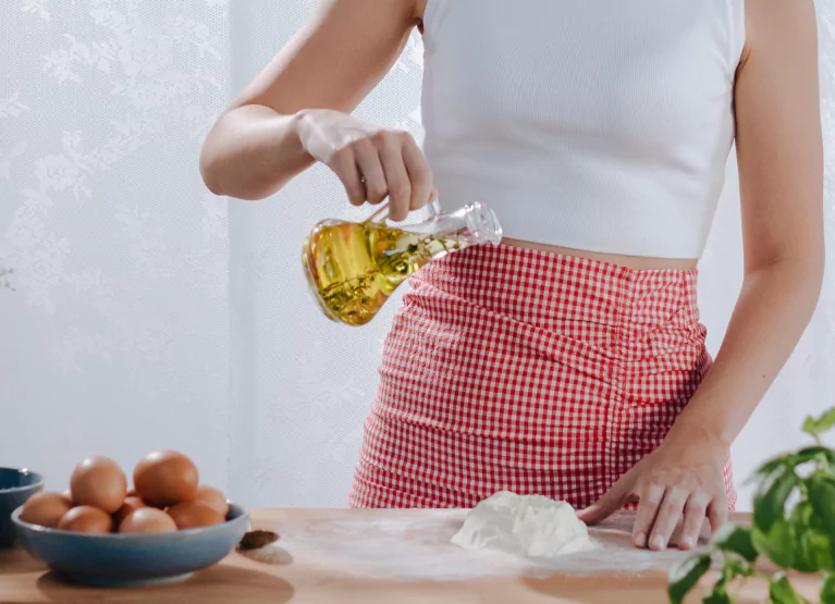 a girl pouring oil onto flour