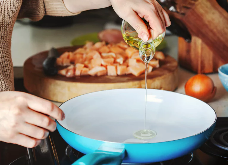 someone pouring oil into a pan