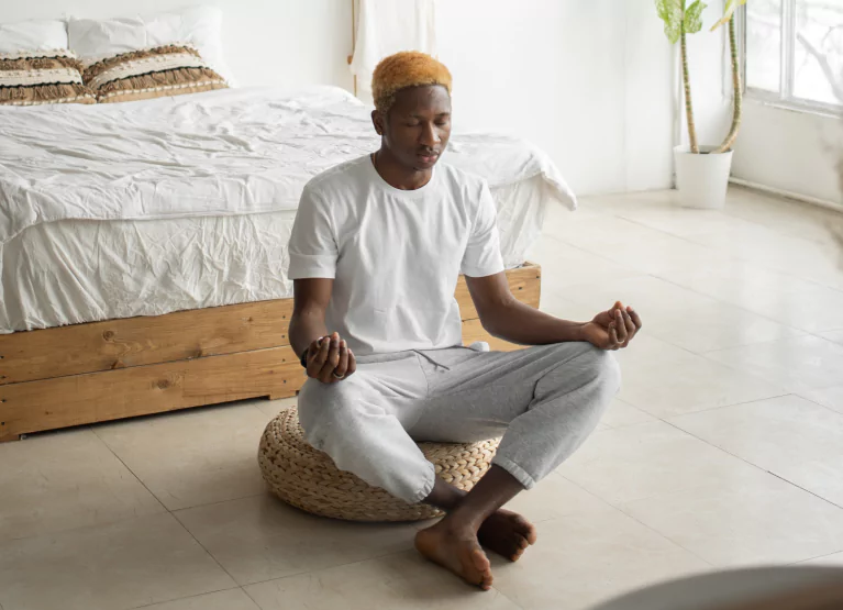 a man meditating in his bedroom