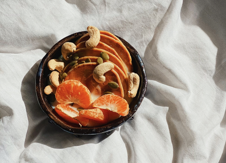 Bowl of cashews, oranges, and dried fruit