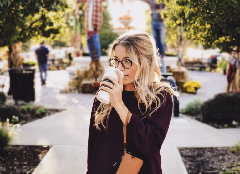 a girl drinking a pumpkin spice latte